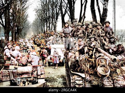 Fanteria britannica che cavalca su carri armati Sherman verso l'area del Reichswald, Germania, febbraio 1945. A sinistra della fotografia, le pistole anticarro e i loro equipaggi possono essere visti. Foto Stock