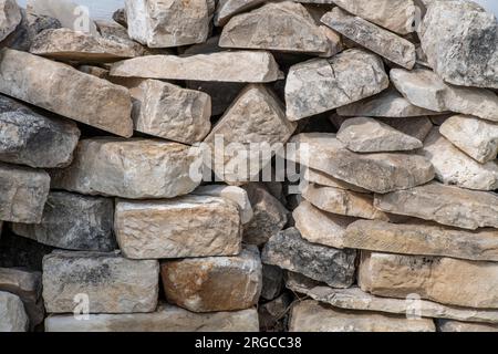 rivestimenti in pietra a secco. sassi posati in modo casuale in un muro a secco. Foto Stock