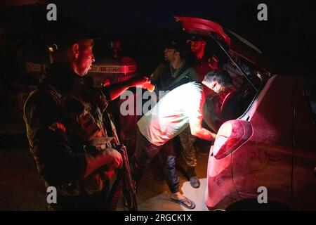 Srinagar, India. 8 agosto 2023. Lo Special Operation Group (SOG) personale della polizia di Jammu e del Kashmir frena un veicolo civile mentre conducono un'operazione di ricerca durante la sera prima del giorno dell'indipendenza dell'India, nella periferia di Srinagar. L'India segna la sua indipendenza dal dominio coloniale britannico il 15 agosto. Credito: SOPA Images Limited/Alamy Live News Foto Stock