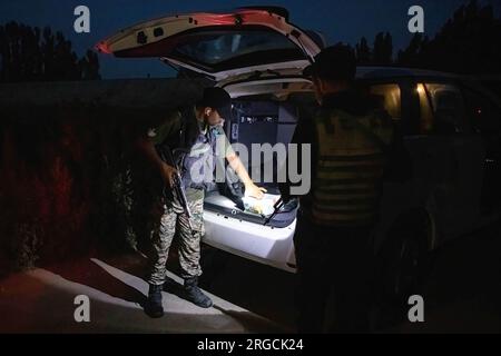 Srinagar, India. 8 agosto 2023. Lo Special Operation Group (SOG) personale della polizia di Jammu e del Kashmir frena un veicolo civile mentre conducono un'operazione di ricerca durante la sera prima del giorno dell'indipendenza dell'India, nella periferia di Srinagar. L'India segna la sua indipendenza dal dominio coloniale britannico il 15 agosto. Credito: SOPA Images Limited/Alamy Live News Foto Stock