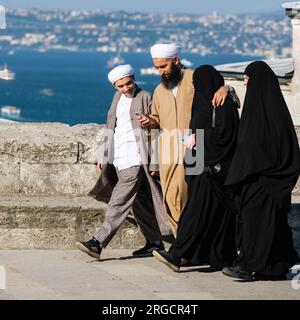 Istanbul, Turchia, Turkiye. Coppia in abito religioso conservatore camminando presso la Moschea di Solimano la magnifica Moschea di Solimano. Foto Stock