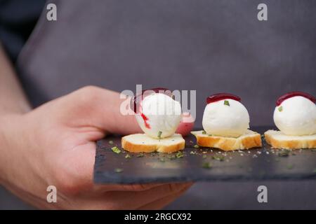 Antipasti al formaggio spalmabile su un piatto di ardesia Foto Stock