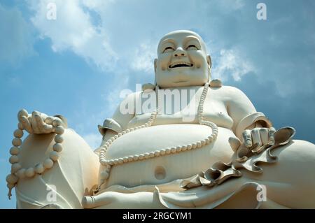 La vista di una grande scultura del monaco Budai nel tempio Vinh Trang del delta del Mekong (Vietnam). Foto Stock