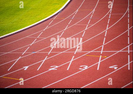 Geometria delle linee bianche e corsie numerate sulla tela audace di una pista rossa - foto di illustrazione di pista e campo per i Mondi di Budapest e i Giochi di Foto Stock