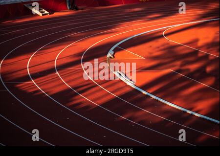 L'impeccabile geometria delle linee bianche e delle corsie numerate sulla tela audace di una pista rossa - foto di illustrazione di pista e campo per Mondi in Budapes Foto Stock