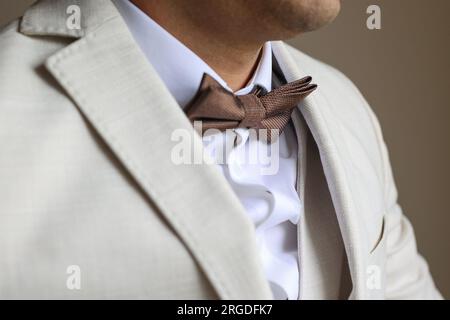 sposo che si mette la cravatta ad arco il giorno del suo matrimonio Foto Stock