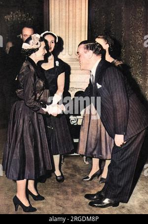 Sir Norman Bishop Hartnell (1901-1979) couturier britannico e design di moda preferito della Regina e della Regina madre, visto salutare un altro mecenate reale, la Principessa Alice, Duchessa di Gloucester (1901-2004), il cui abito da sposa ha progettato, ad un ricevimento di acquirenti di moda dall'estero tenutosi alla Mansion House nella City di Londra nel 1955. L'accoglienza è stata data da Lady Pamela Berry (ex Lady Pamela Smith) e ha visto la partecipazione dei principali designer di Londra, dei compratori d'oltremare, dei rappresentanti della stampa e del presidente del Board of Trade, Peter Thorneycroft e sua moglie. Foto Stock