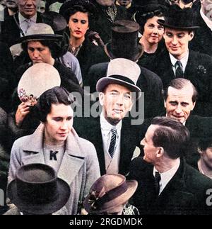 Noel Coward (Sir Noel Peirce Coward, 1899-1973), attore, cantante, drammaturgo inglese, direttore e compositore, con un cappello grigio, e raffigurato fuori Buckingham Palace, dove era tra la folla a guardare la processione dell'incoronazione di re Giorgio vi il 12 maggio 1937. Foto Stock