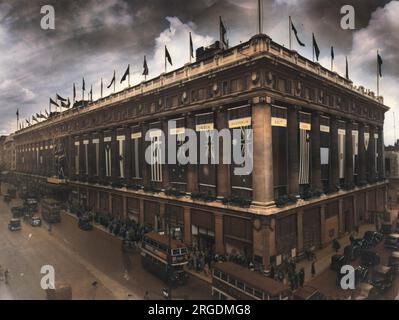 Il grande magazzino di Selfridge a Oxford Street, Londra, raffigurato durante la seconda guerra mondiale con le finestre coperte come protezione contro i raid aerei, e con le bandiere degli alleati del Regno Unito appese tra le sue colonne. Foto Stock