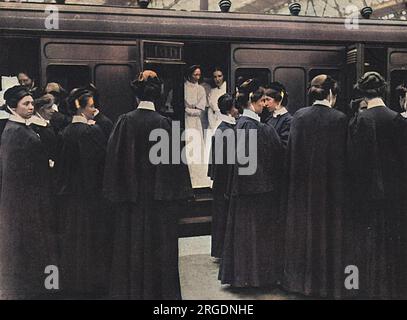 Le donne si sono offerte volontarie nelle loro migliaia per diventare infermiere durante i primi mesi della prima guerra mondiale Qui un distaccamento di infermiere sale a bordo di un treno da London Waterloo a Portsmouth per lavorare con la Croce Rossa britannica. Foto Stock