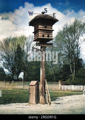 Il villaggio di Westcott, Surrey, in Inghilterra, ha un segno caratteristico e intelligente. Sopra la colomba si trovano le lettere "W", "e" e il braccio nord mostra una "T" = "ovest" + (colomba) cote! Foto Stock