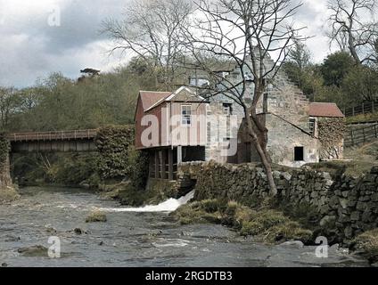 Vista di un mulino sul lato di un fiume. Foto Stock