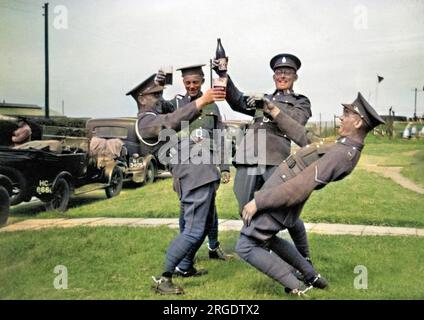 Quattro soldati che gustano un bicchiere (o una bottiglia) di birra vicino a Okehampton, Devon. Foto Stock