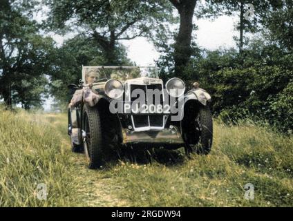 Un uomo che guida un'auto sportiva lungo una corsia erbosa nel paese. Foto Stock