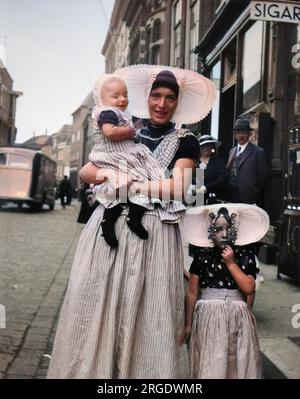 Una donna e due bambini in abito tradizionale in una strada a Middleburg, Olanda. Foto Stock