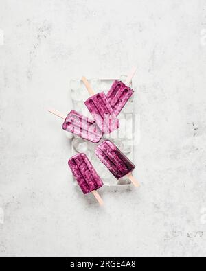 Ghiaccioli Vegan Cherry Coconut su ghiaccio su piatto bianco Foto Stock