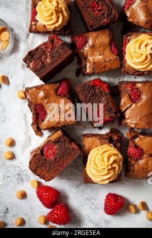 Brownie al cioccolato e lamponi con glassa di crema su alcune delle caselle Foto Stock