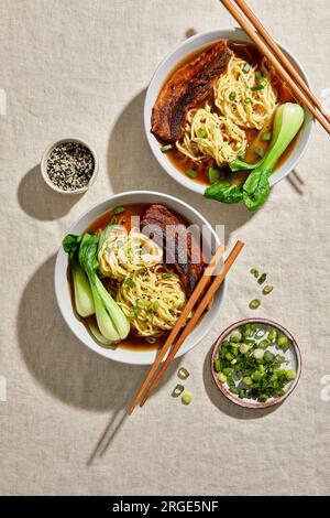 Pancia di maiale Ramen, Bok Choy e uovo con sfondo neutro chiaro Foto Stock