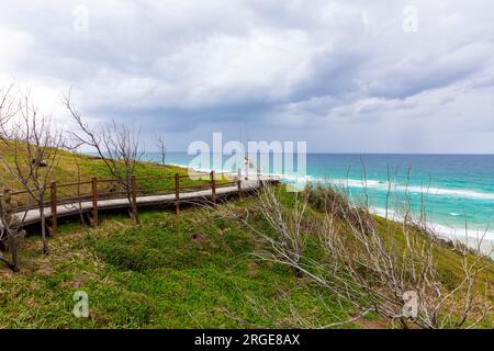 Piscine con champagne sulla spiaggia di 75 miglia di Fraser Island K'gari, donne che camminano fino alle piscine lungo la passerella in legno, Queensland, Australia Foto Stock