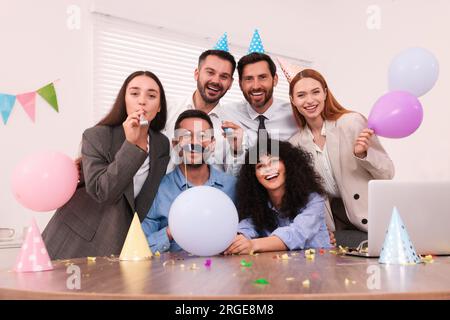 I colleghi si divertono durante le feste in ufficio al chiuso Foto Stock