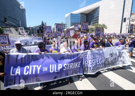 Los Angeles, Stati Uniti. 8 agosto 2023. I manifestanti marciano con striscioni e cartelli che esprimono le loro opinioni durante una manifestazione. Più di 11.000 lavoratori della città di Los Angeles picchettano fuori dal Los Angeles City Hall abbandonando il lavoro per uno sciopero di 24 ore che accusava pratiche di lavoro sleali. Credito: SOPA Images Limited/Alamy Live News Foto Stock