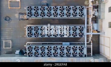 Tre file di ventilatori a spirale sul tetto di un edificio. Vista droni Foto Stock