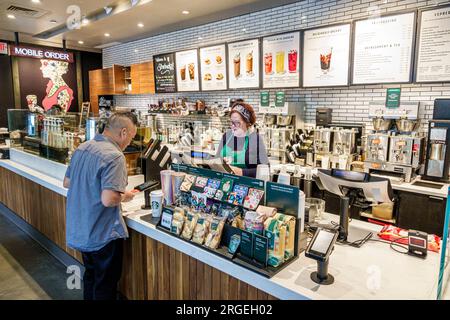 Charlotte North Carolina, Starbucks Coffee, barista che prende ordini, scanner per carte di credito, uomo uomo uomo uomo uomo, donna donna donna donna donna, adulti residenti, interno interi Foto Stock