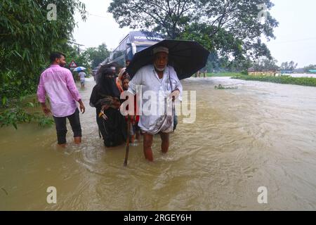 Chattogram. 9 agosto 2023. I pedoni attraversano una strada allagata a Chattogram, Bangladesh, l'8 agosto 2023. Giorni di piogge torrenziali hanno devastato la città portuale del Bangladesh, Chattogram, a circa 242 km a sud-est della capitale Dhaka, inondando aree basse e disturbando il traffico stradale con il più alto downpour finora registrato quest'anno lunedì.strade, le corsie e le corsie in alcune parti della principale città portuale del paese sono andate sotto le caviglie fino ad acqua profonda al ginocchio, causando enormi difficoltà ai pendolari e ai suoi milioni di abitanti. Crediti: Xinhua/Alamy Live News Foto Stock