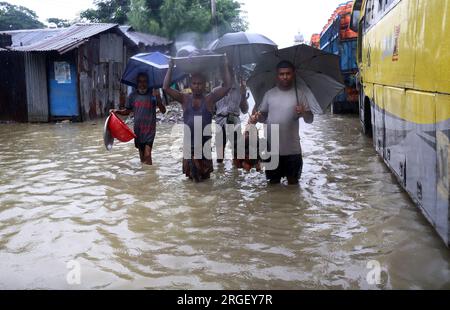 Chattogram. 9 agosto 2023. I pedoni attraversano una strada allagata a Chattogram, Bangladesh, l'8 agosto 2023. Giorni di piogge torrenziali hanno devastato la città portuale del Bangladesh, Chattogram, a circa 242 km a sud-est della capitale Dhaka, inondando aree basse e disturbando il traffico stradale con il più alto downpour finora registrato quest'anno lunedì.strade, le corsie e le corsie in alcune parti della principale città portuale del paese sono andate sotto le caviglie fino ad acqua profonda al ginocchio, causando enormi difficoltà ai pendolari e ai suoi milioni di abitanti. Crediti: Xinhua/Alamy Live News Foto Stock