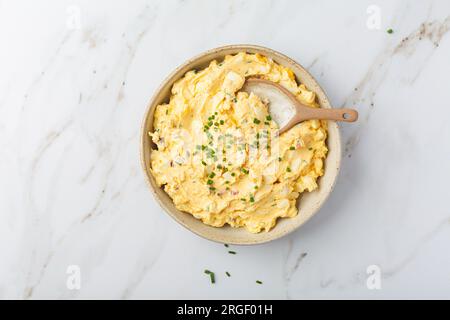 Uova fatte in casa con cipolla, pancetta e erba cipollina su fondo di marmo Foto Stock