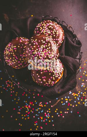 Ciambelle berlinesi, ripiene di marmellata e coriandoli colorati Foto Stock