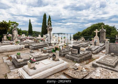 Cavtat, Croazia 07-26-2023 Cimitero storico del villaggio di pescatori di Cavtat vicino a Dubrovnik con il mausoleo della famiglia Racic in cima alla collina Foto Stock