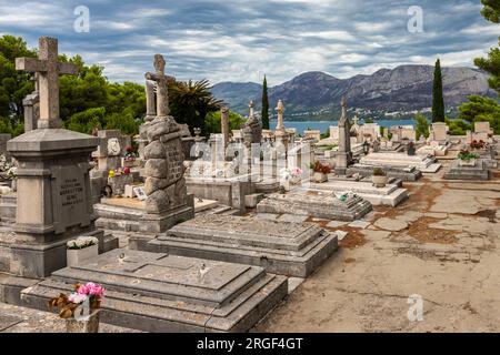 Cavtat, Croazia 07-26-2023 Cimitero storico del villaggio di pescatori di Cavtat vicino a Dubrovnik con il mausoleo della famiglia Racic in cima alla collina Foto Stock