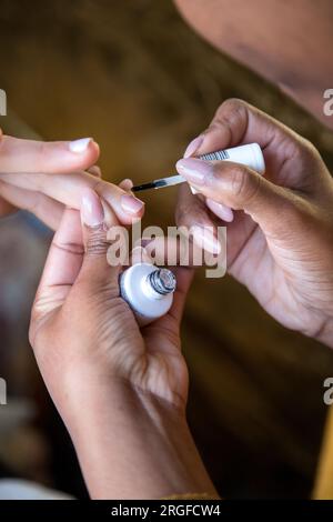 Donna che si prende cura delle unghie con un servizio di manicure. Mani di una persona con una manicure. Fasi del processo Foto Stock