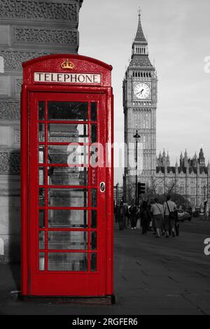 Cabina telefonica rossa isolata di colore vicino al Big Ben a Londra su un ambiente bianco e nero. Foto Stock