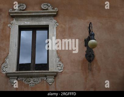 Antica finestra neoclassica con finiture in marmo scolpite su un muro in stucco veneziano a Taormina, Sicilia. Foto Stock