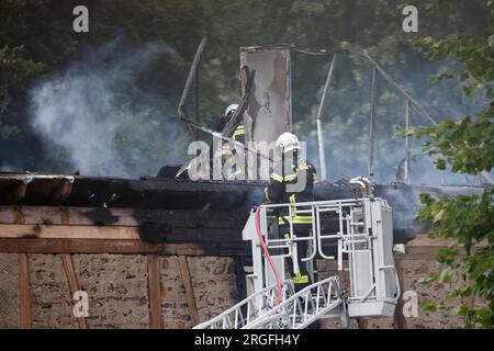 Wintzenheim, Francia. 9 agosto 2023. Vigili del fuoco che lavorano sulla scena dell'incidente. La polizia francese crede che nove persone siano morte finora dopo un incendio in una casa vacanze. L'incendio scoppiò intorno alle 6.30 in una casa vacanze che aveva ospitato due gruppi di adulti disabili con disabilità mentali lievi che avevano viaggiato da Nancy. Credito: Philipp von Ditfurth/dpa/Alamy Live News Foto Stock