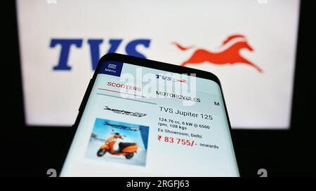 Telefono cellulare con pagina Web dell'azienda motociclistica TVS Motor Company Limited sullo schermo davanti al logo. Mettere a fuoco in alto a sinistra sul display del telefono. Foto Stock