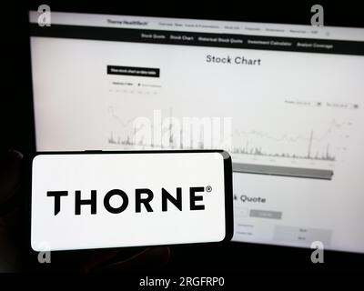 Persona che possiede un telefono cellulare con il logo della società americana di benessere Thorne HealthTech Inc. Sullo schermo di fronte alla pagina Web. Concentrarsi sul display del telefono. Foto Stock