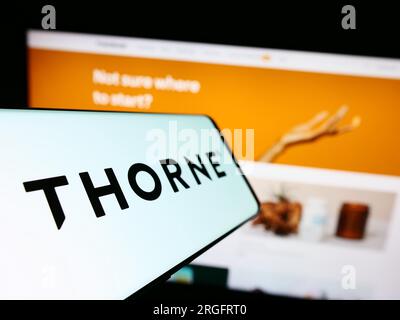 Smartphone con logo della società americana di benessere Thorne HealthTech Inc. Sullo schermo di fronte al sito Web. Mettere a fuoco il display centrale sinistro del telefono. Foto Stock