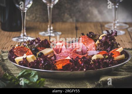 Antipasti italiani tradizionali su un piatto servito con olive. Aperitivo, pranzo o buffet in un ristorante. Foto Stock