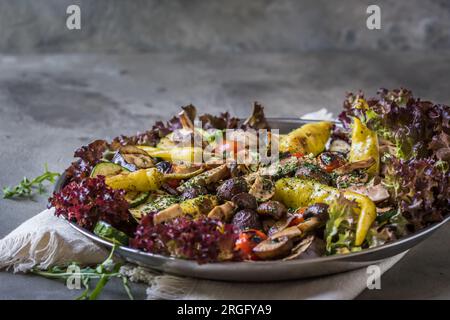 Verdure alla griglia con insalata e olive, antipasti italiani, su sfondo grigio, spazio copia Foto Stock
