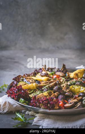 Verdure grigliate con insalata e olive, antipasti italiani, su sfondo grigio, verticale con spazio copia Foto Stock
