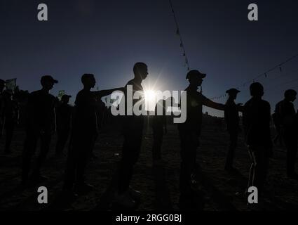 Gaza, Palestina. 8 agosto 2023. I giovani palestinesi partecipano a un campo estivo militare organizzato dalle Brigate al-Qassam, l'ala militare di Hamas, a Khan Yunis, nella Striscia di Gaza meridionale. (Foto di Yousef Masoud/SOPA Images/Sipa USA) credito: SIPA USA/Alamy Live News Foto Stock