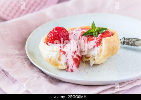 Panino con croissant fatto in casa ripieno di panna e purè di fragole Foto Stock