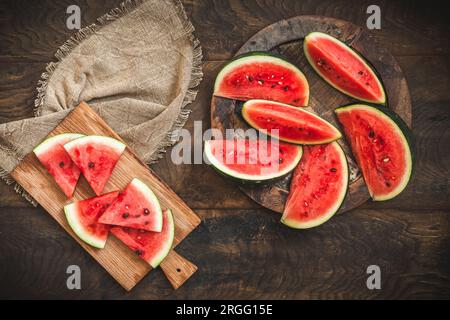 Anguria fresca a fette su sfondo rustico in legno, vista dall'alto Foto Stock