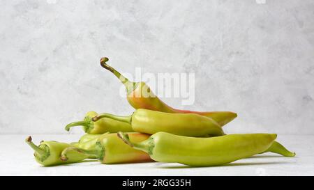 pila di peperoni di banana sul tavolo bianco, capsicum annuum, peperoncino lungo, forma curva con calore delicato e sapore piccante e leggermente dolce Foto Stock