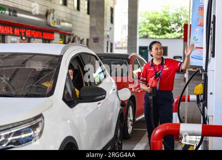 Fuyang, Cina. 9 agosto 2023. Una lavoratrice di una stazione di servizio spiega i prezzi della benzina ai proprietari di auto a Fuyang. La Commissione cinese per lo sviluppo e la riforma (NDRC) ha annunciato che i prezzi nazionali della benzina e del diesel saranno aumentati rispettivamente di 240 yuan/tonnellata e di 230 yuan/tonnellata a partire dalle 24:00. (Foto di Sheldon Cooper/SOPA Images/Sipa USA) credito: SIPA USA/Alamy Live News Foto Stock