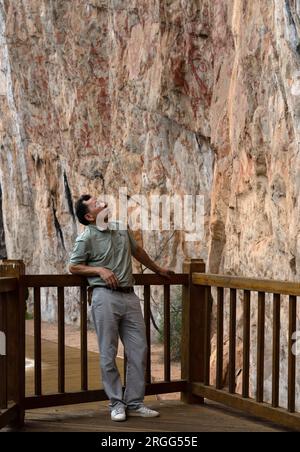 (230809) -- NINGMING, 9 agosto 2023 (Xinhua) -- Zhu Qiuping, un esperto di protezione delle reliquie culturali, contempla dipinti rupestri di Huashan nella contea di Ningming, nella città di Chongzuo, nella regione autonoma di Guangxi Zhuang nel sud della Cina, 8 agosto 2023. Il sito di Zuojiang Huashan ospita oltre 1.900 disegni ben conservati sulla faccia delle montagne Huashan lungo il fiume Zuojiang e il suo affluente Mingjiang a Chongzuo. I dipinti di rosso brunastro, creati dal periodo degli Stati combattenti (475-221 a.C.) alla dinastia Han orientale (25-220), raffigurano i sacrifici del popolo Luoyue, antenati degli odierni Zhuang Foto Stock