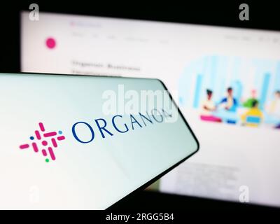 Telefono cellulare con logo della società farmaceutica americana Organon Co. Sullo schermo davanti al sito Web. Mettere a fuoco il display centrale sinistro del telefono. Foto Stock